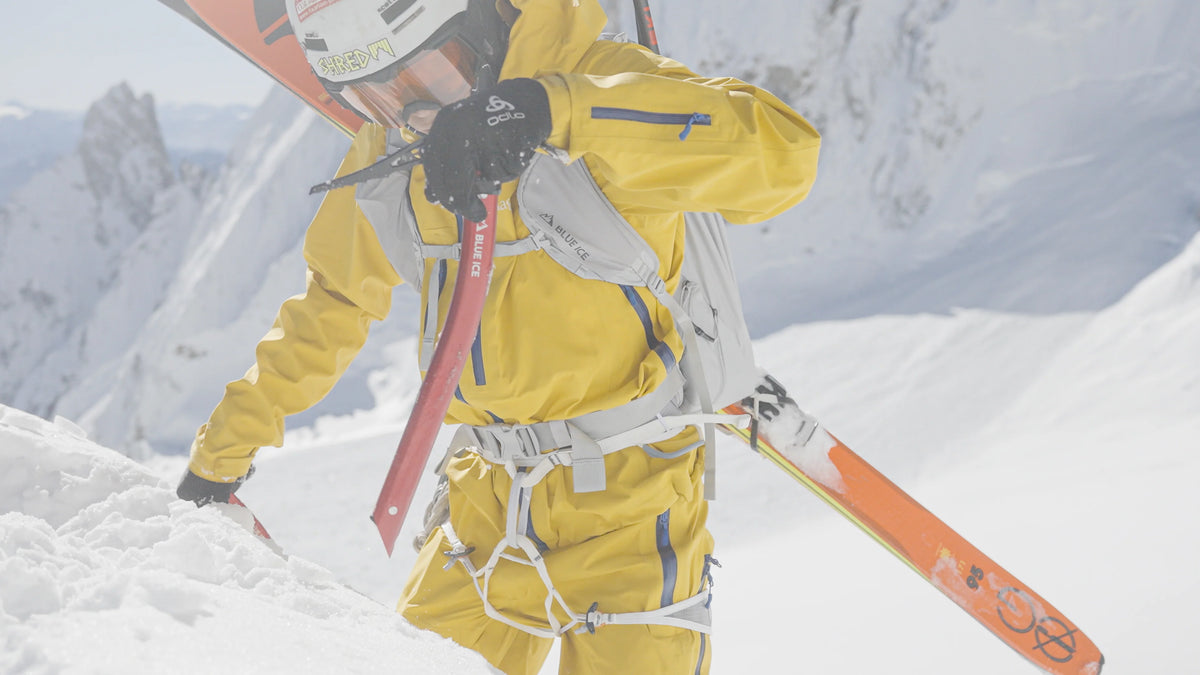 Ice climbing harness worn by a climber on snowy terrain, with straps visible