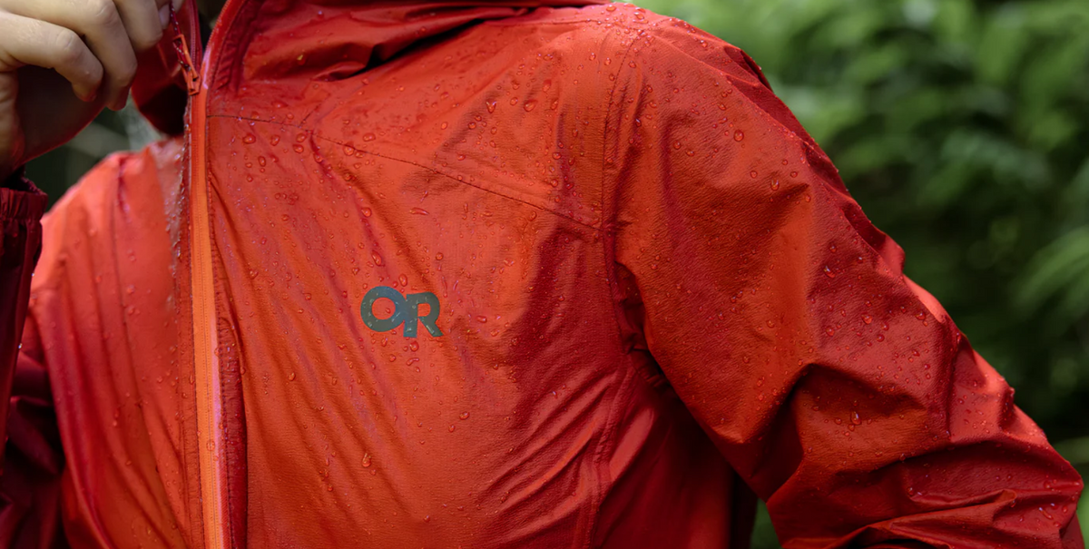 Red shell jacket with water droplets beading on the fabric