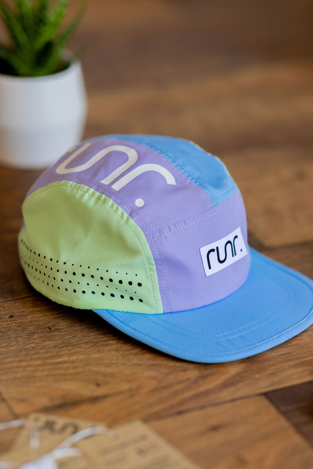 Color-block running cap with light blue brim and purple mint panels, RUNR logo patch