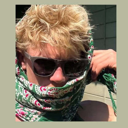 Dark sunglasses worn with patterned face covering