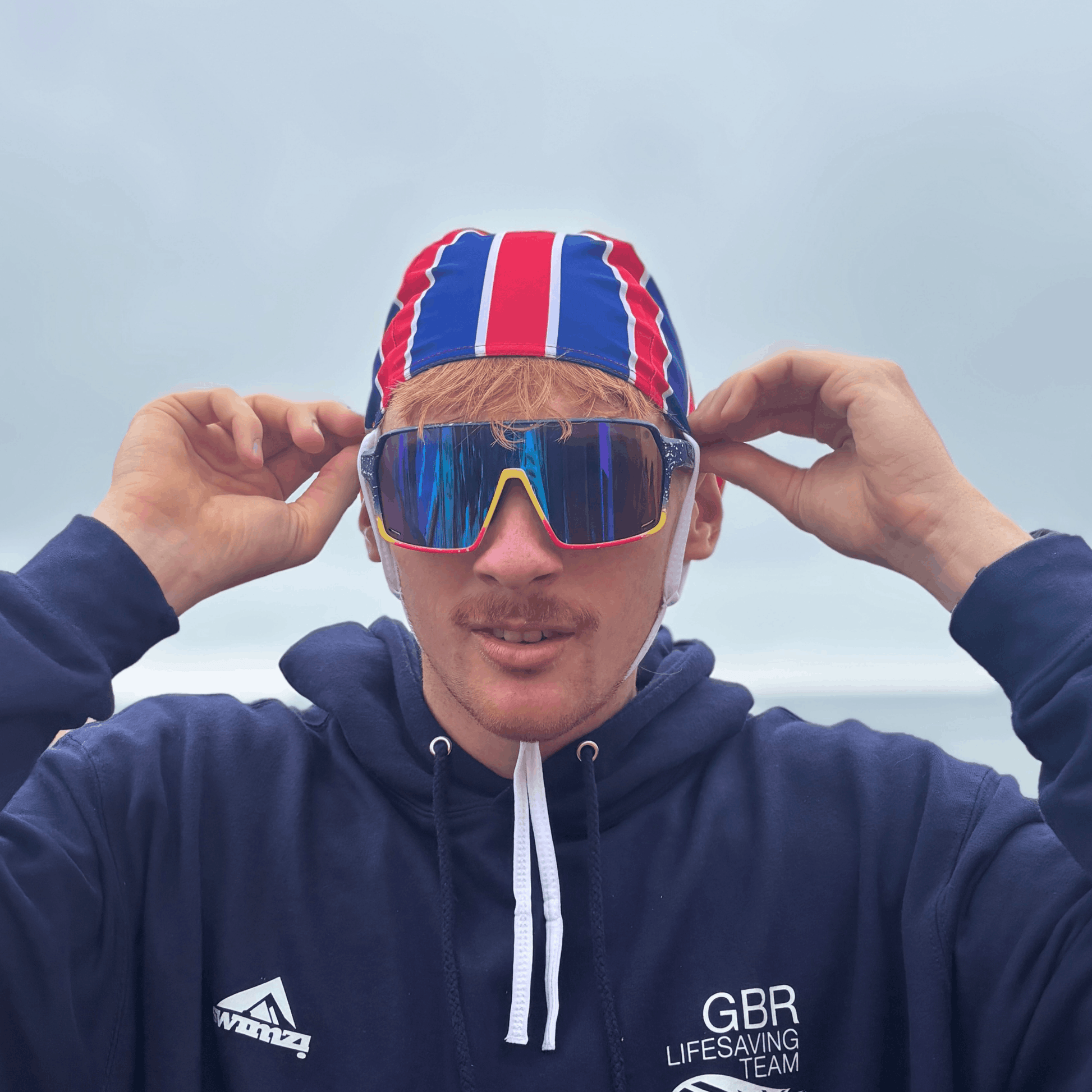 Wraparound sports sunglasses on a person, blue frames and multicolour mirrored lenses