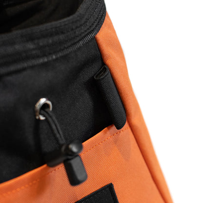 Orange chalk bucket with black drawstring cord and metal clip on front panel
