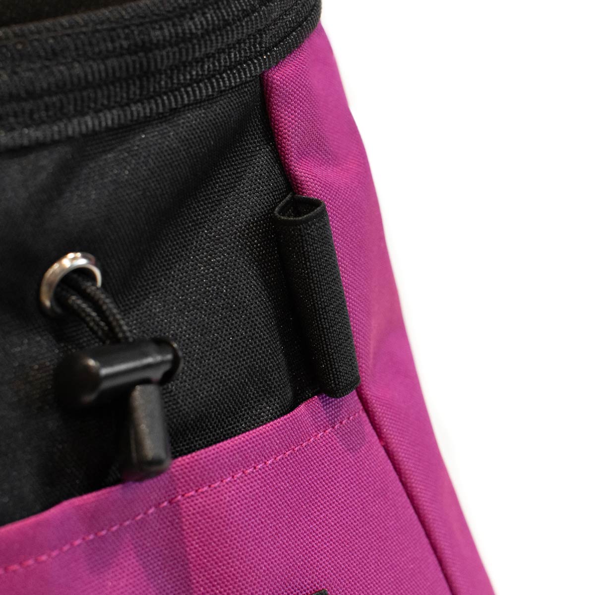 Close-up of black grommet and front flap on a purple bouldering chalk bucket