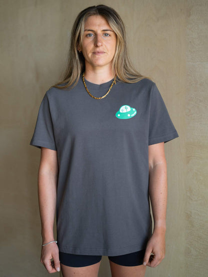 Grey organic cotton T-shirt on model, small circular alien mountain chest graphic