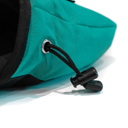 Turquoise climbing chalk bag close-up with black drawcord adjuster and grommet