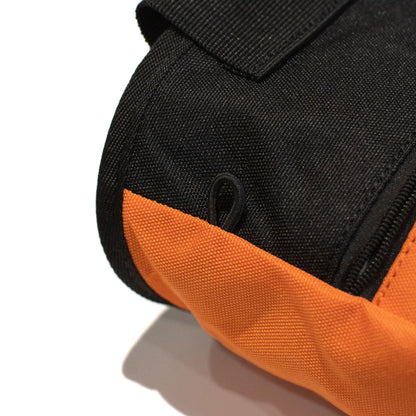 Orange and black climbing chalk bag close-up with zipper pull and fabric seam