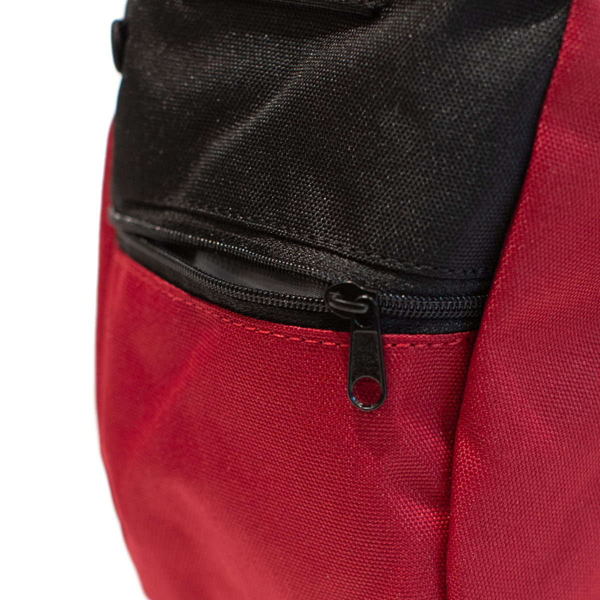 Red chalk bag with black top panel and front zipper with pull tab