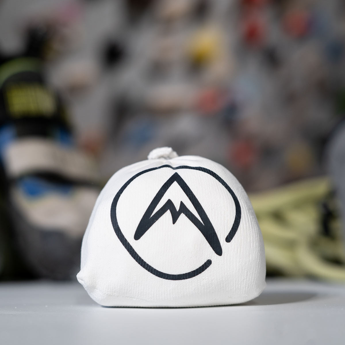 Psychi white chalk ball with mountain logo on a ledge