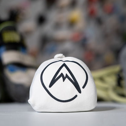 Psychi white chalk ball with mountain logo on a ledge