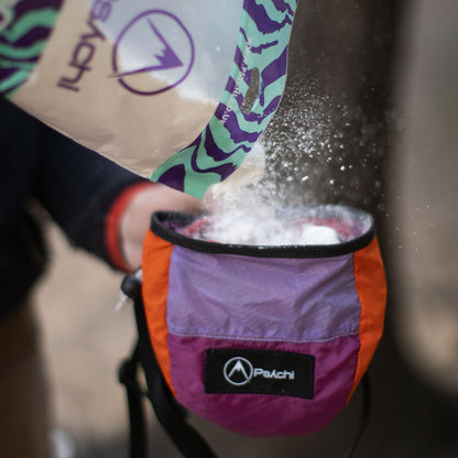 Climbing chalk in an open chalk bag, white powder spilling onto climbing gear