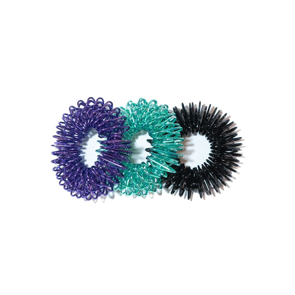 Three finger coil massager rings in purple, teal, and black overlapping side by side