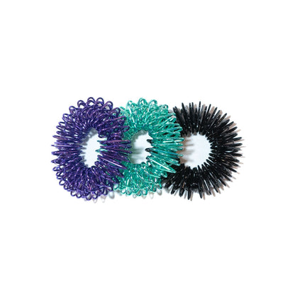 Three finger coil massager rings in purple, teal, and black overlapping side by side