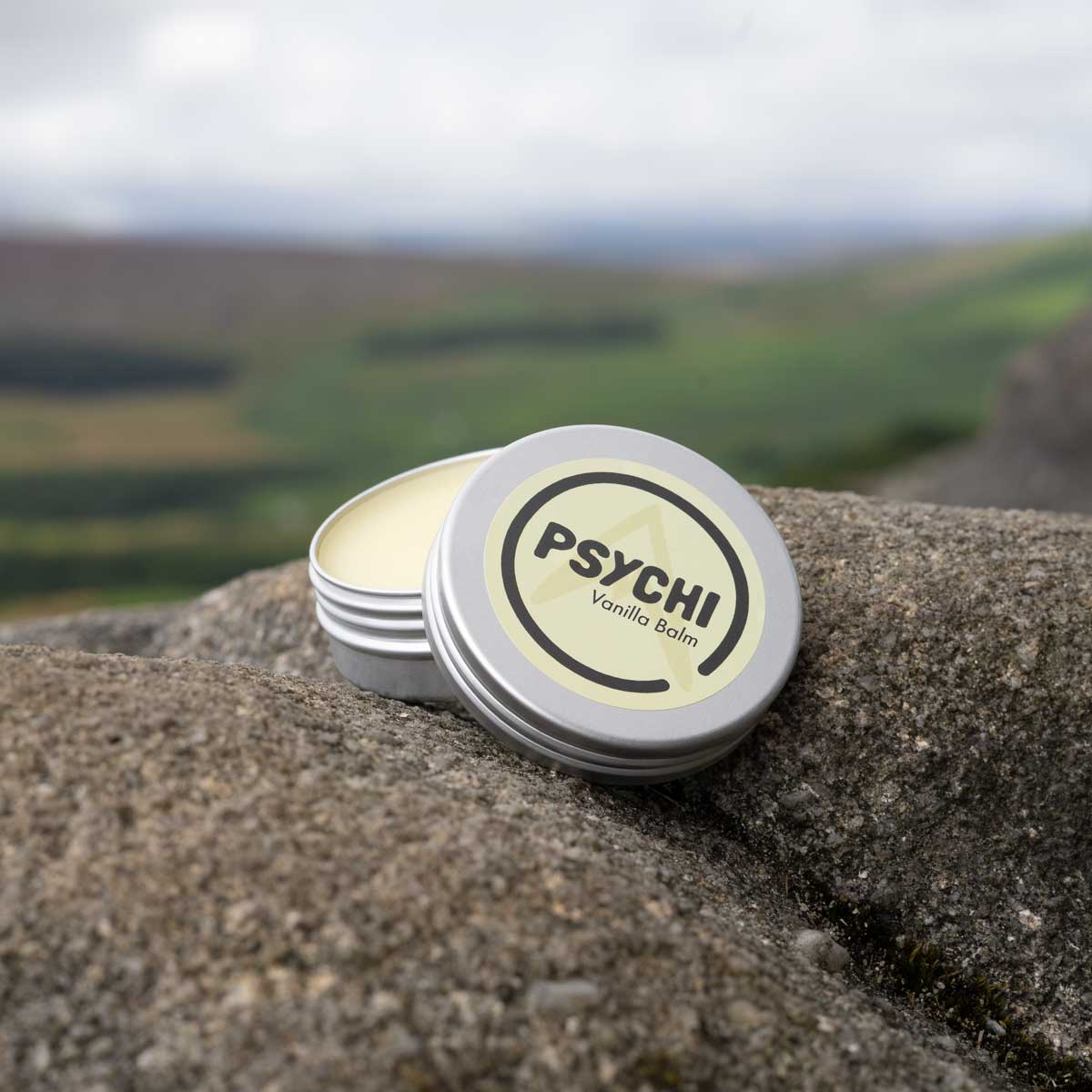PSYCHI Vanilla balm tin on rock with open lid showing balm