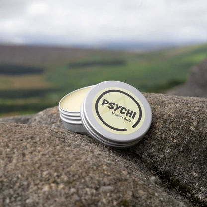 PSYCHI Vanilla balm tin on rock with open lid showing balm