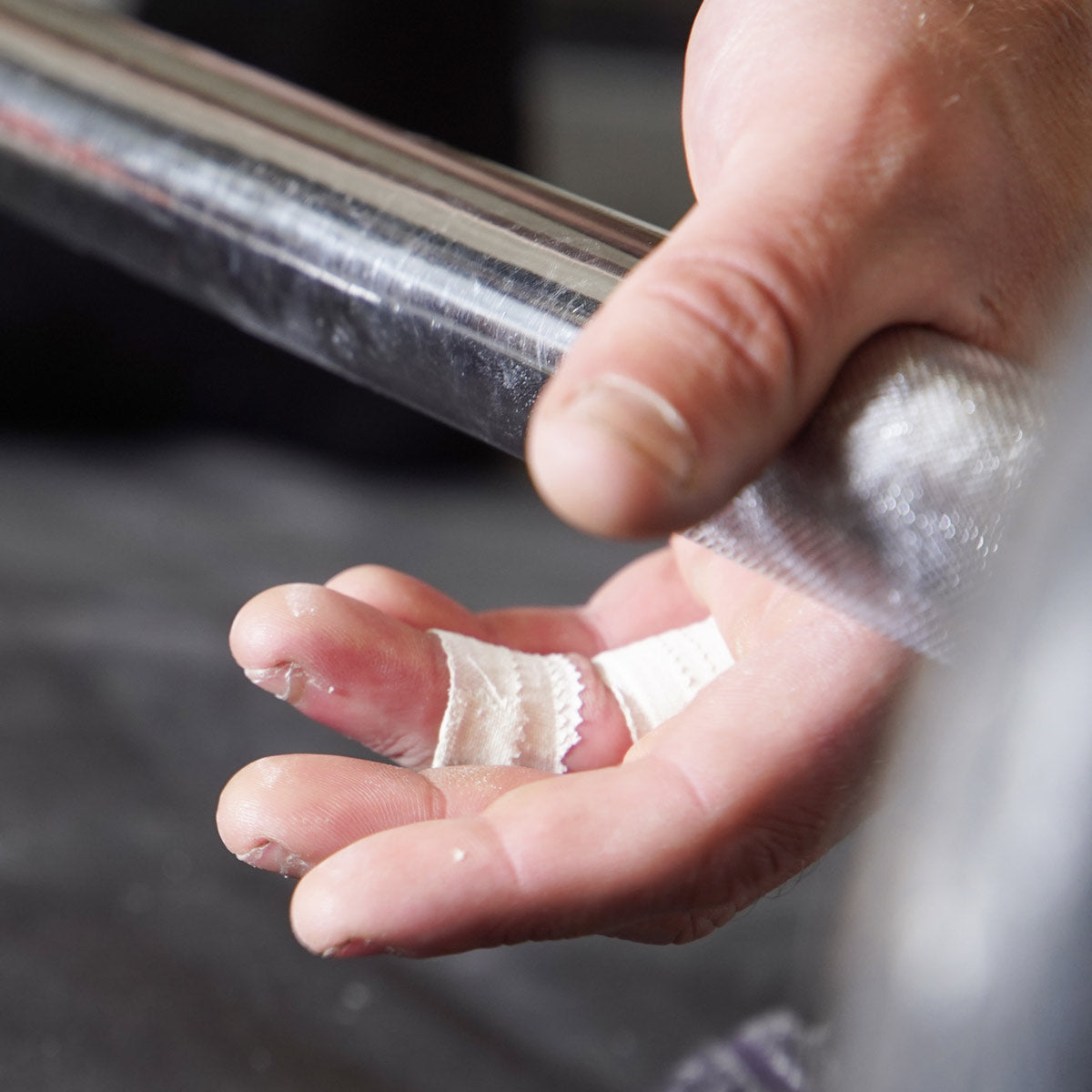 Climbing finger tape being applied to a finger for grip support