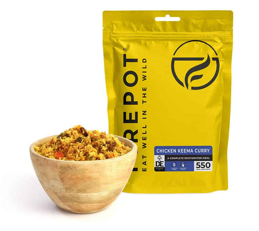 Dehydrated chicken keema curry pouch with bowl of spiced mix, yellow pack