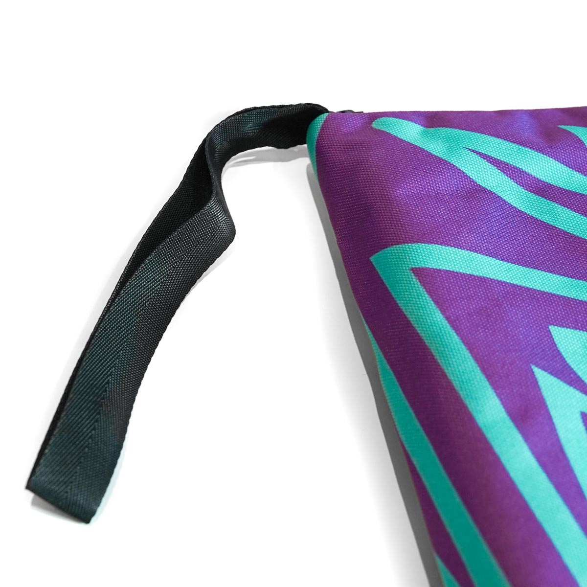 Weatherproof climbing guidebook cover detail with black strap and purple/teal geometric print