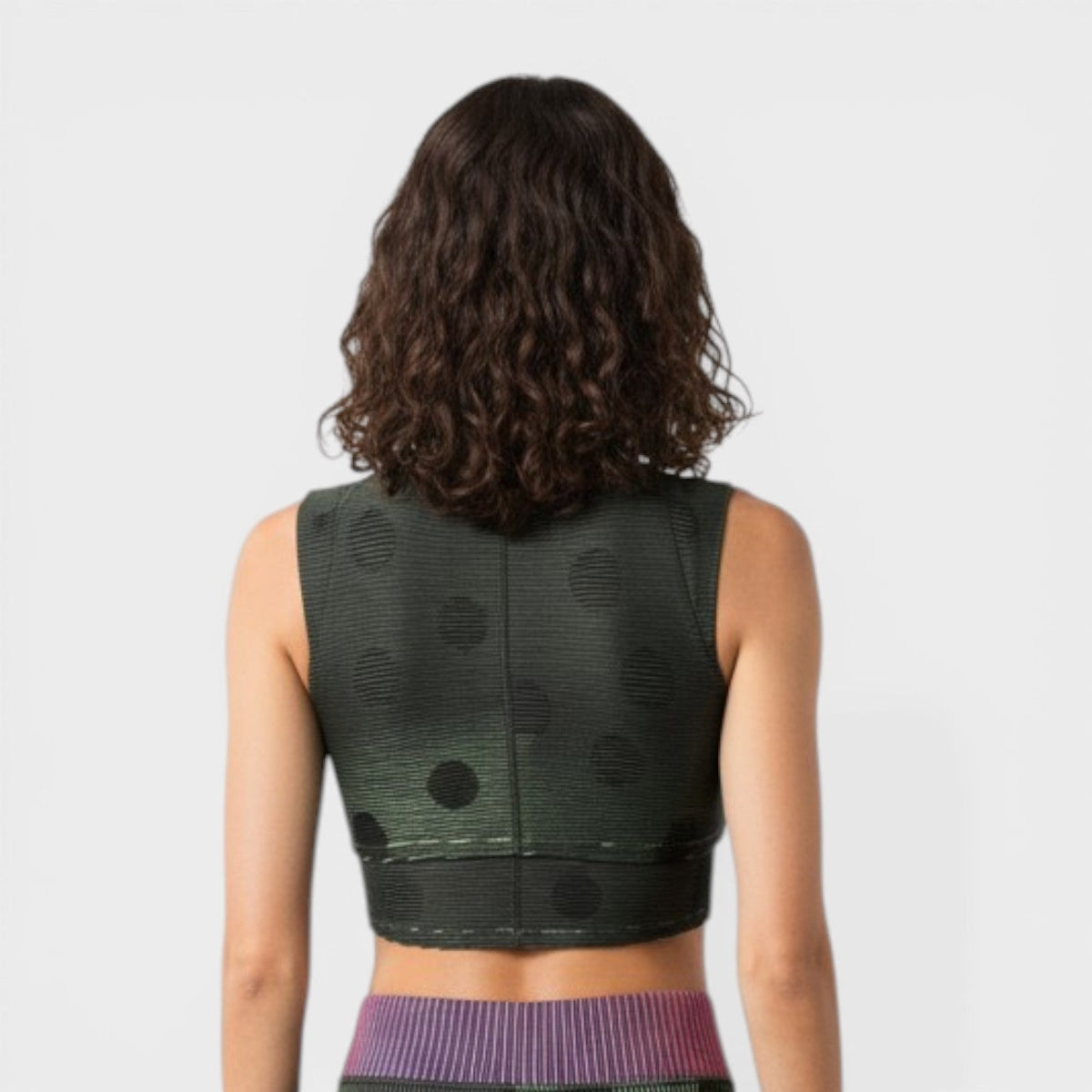 Back view of sleeveless cropped top in dark gray/black with textured dots and purple hem trim