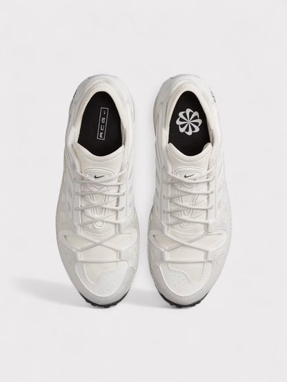 Pair of white lace-up Nike ACG sneakers, toe and tongue with black heel accents