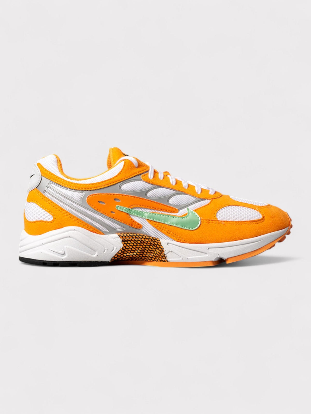Nike orange and white running shoes with green swoosh, lace-up design