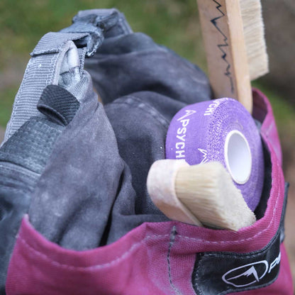 Purple PSYCHI finger tape roll and backing tape on a wooden handle and glove.