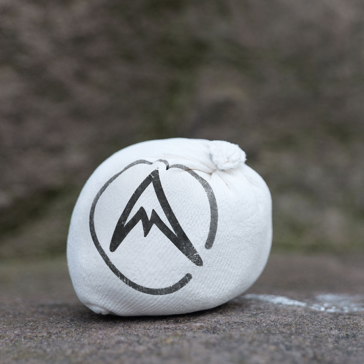 White chalk pouch with black mountain logo on textured surface