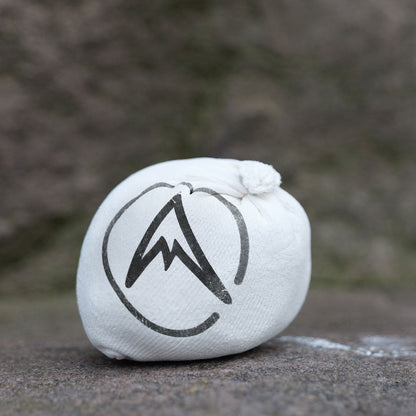 White chalk pouch with black mountain logo on textured surface