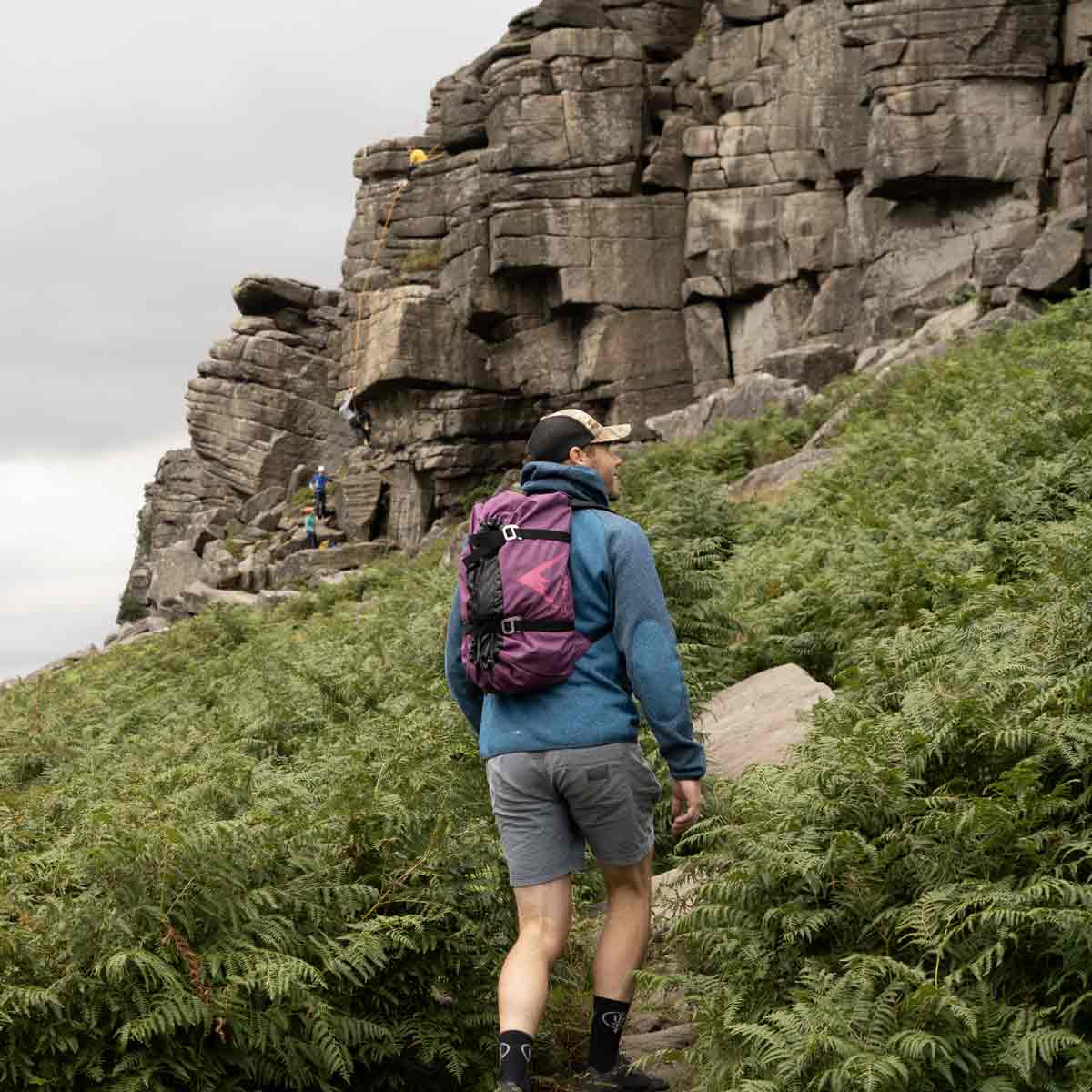 Violet climbing rope bag worn on a hiker’s back with black shoulder straps