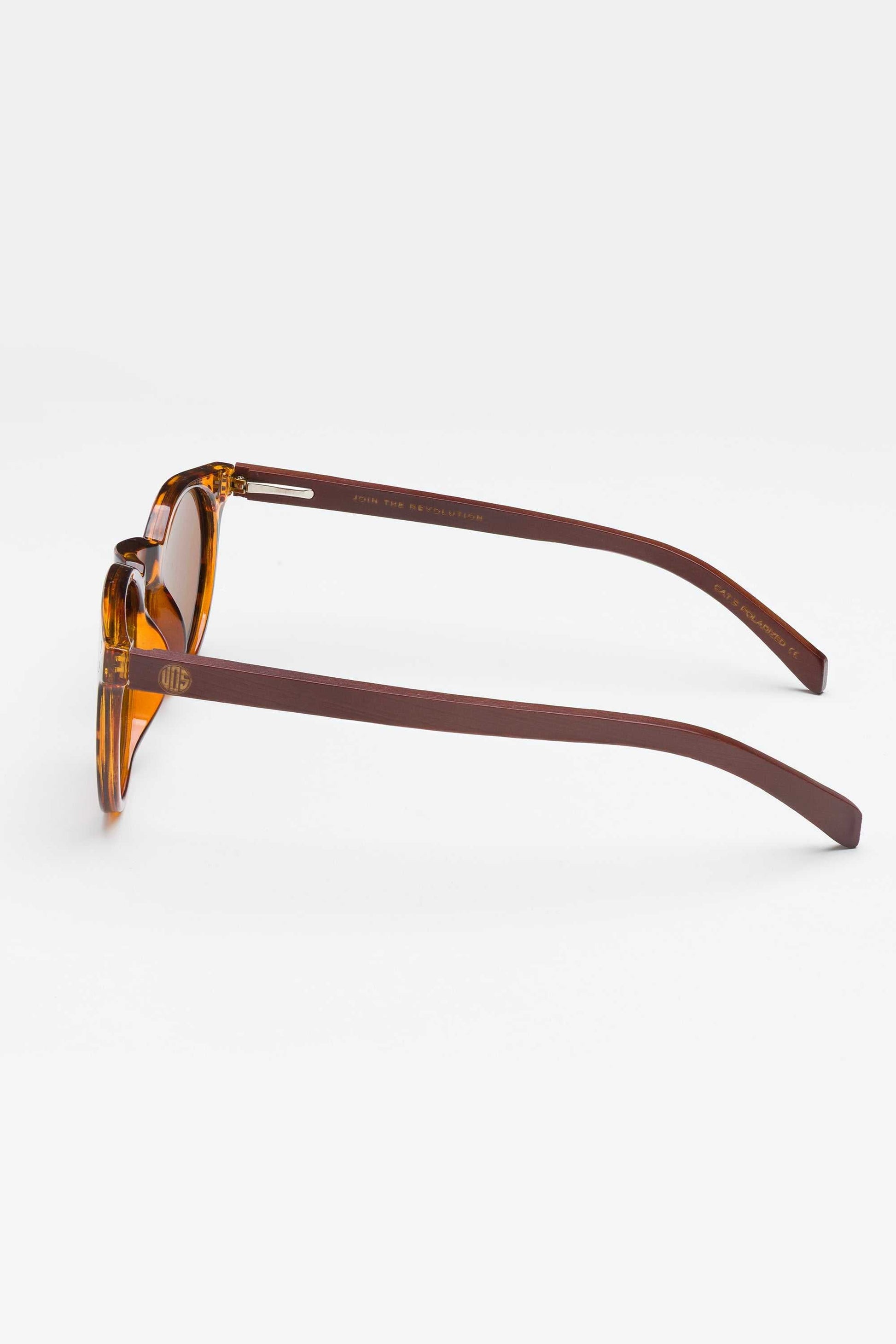 Tortoiseshell sunglasses, side view, with brown tinted lenses and slim arms.