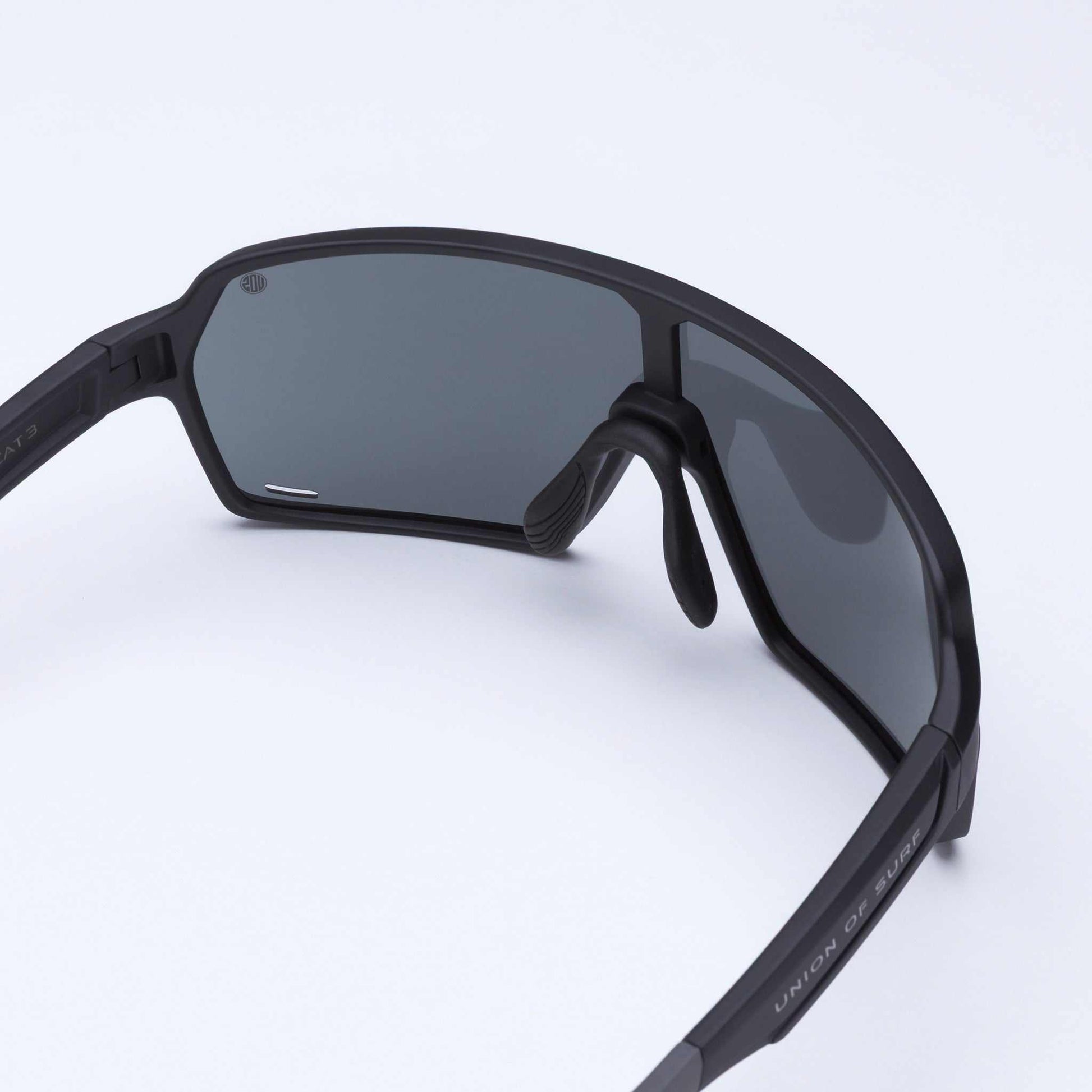 Black wraparound sport sunglasses, side view, dark gray shield lenses