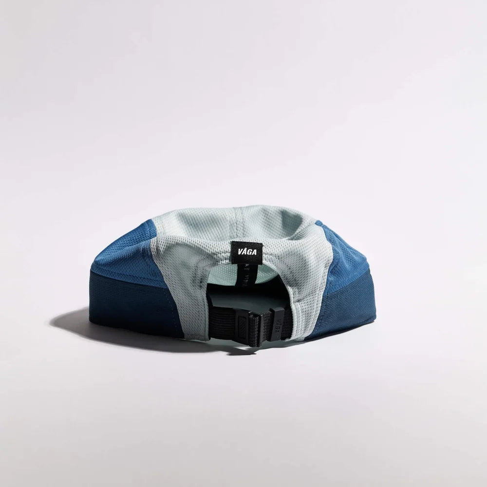 Blue and gray cap with a black strap on a light gray background
