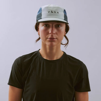 Person wearing a cap with 'Vaga' logo on a plain background