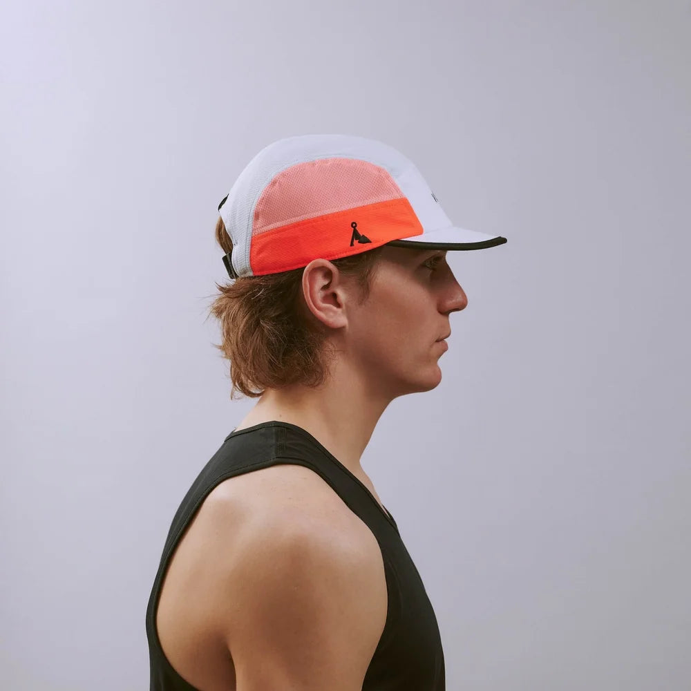 Person wearing a white and orange cap with a logo on a plain background