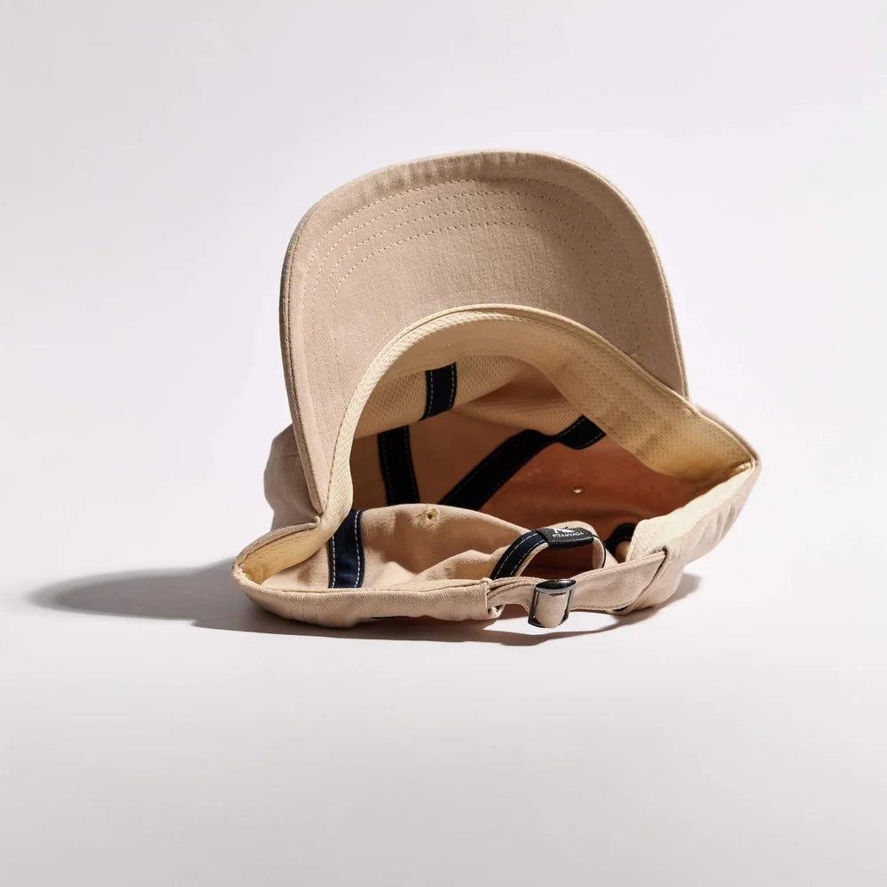 Beige cap with a strap on a light gray background