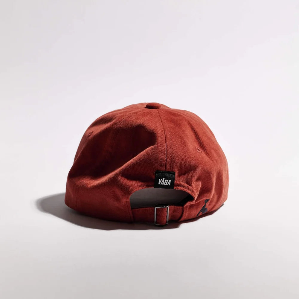 Red cap with a visible brand logo on a light gray background