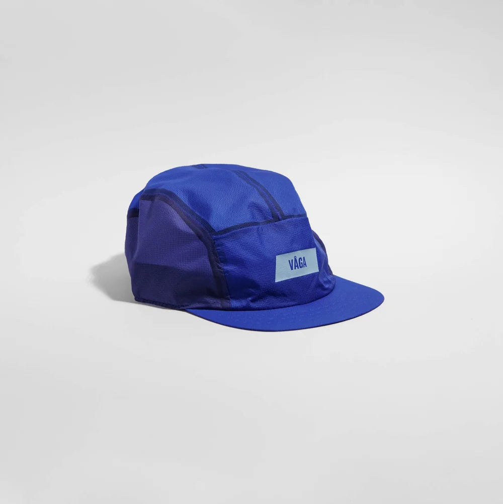 Blue cap with 'VAGA' logo on a light gray background