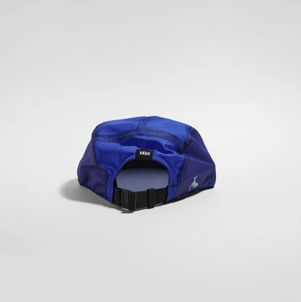 A royal blue athletic cap shown from the back, featuring a black adjustable strap and a small black brand patch with white text.