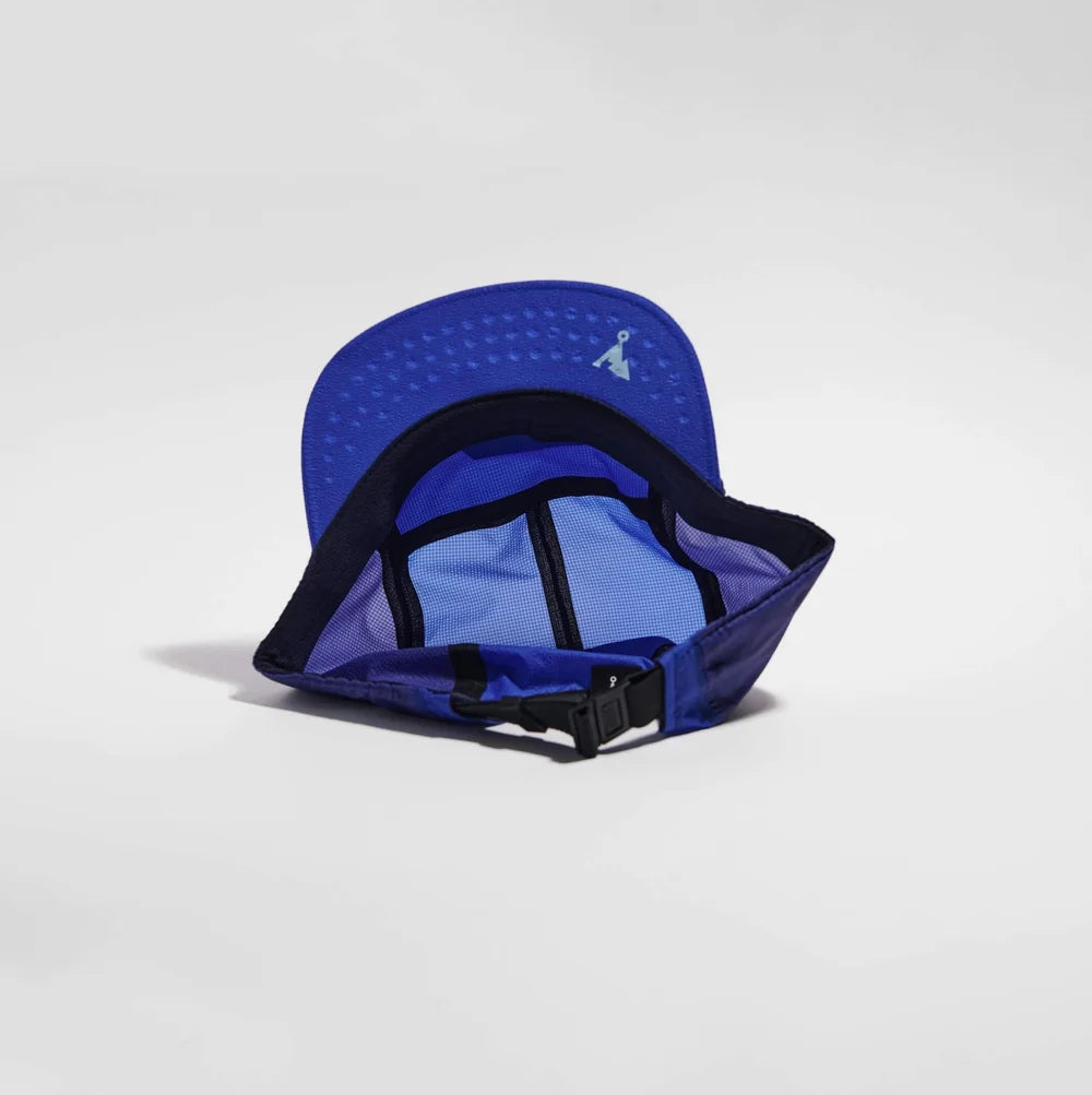Blue cap with black interior and strap on a light gray background