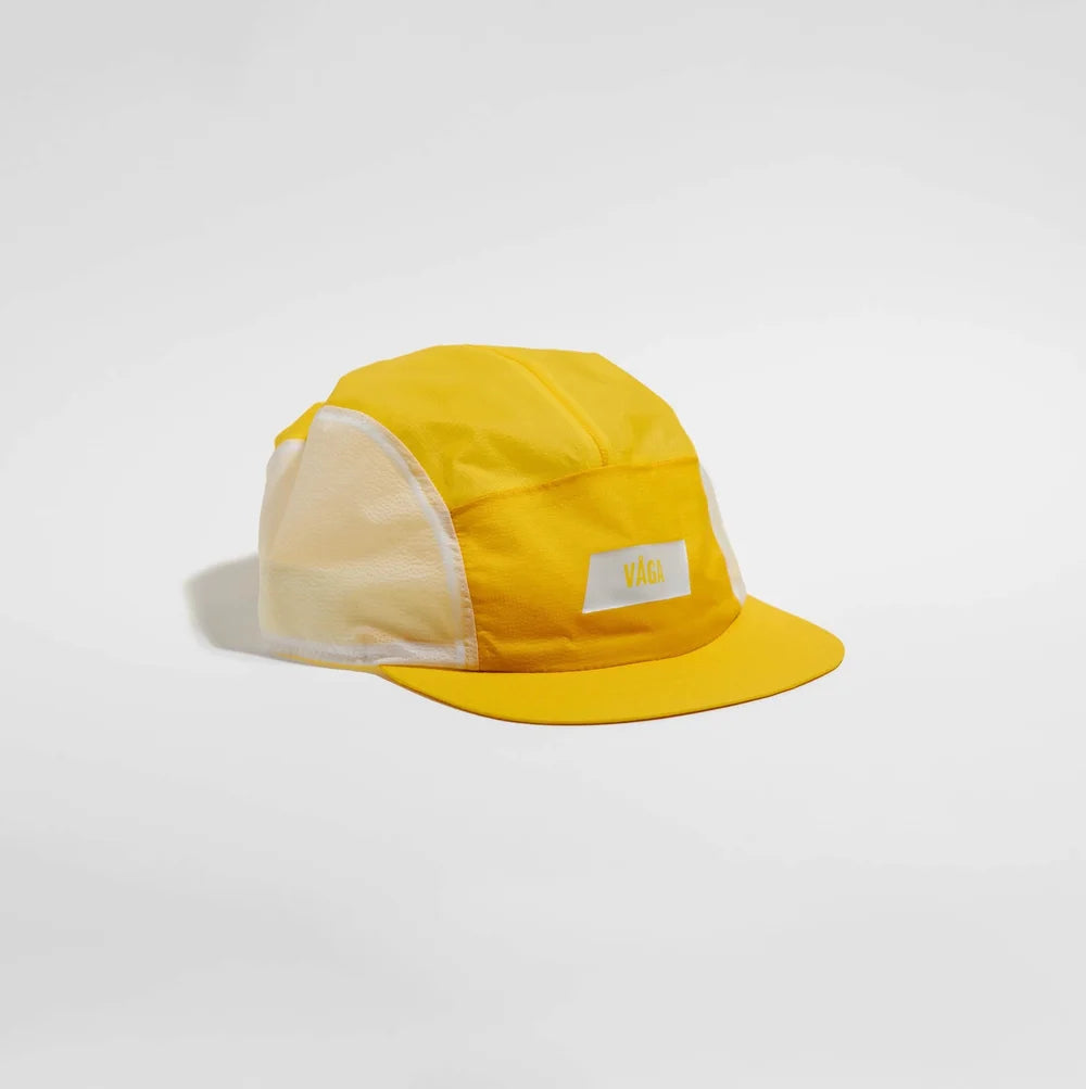 A yellow 5-panel camp cap with white mesh side panels and a small white front patch featuring a yellow logo, set against a plain light gray background.
