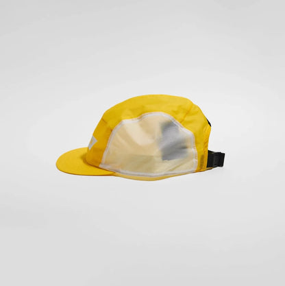 A yellow 5-panel cap with a mesh back and a black adjustable strap, photographed on a light gray studio background.