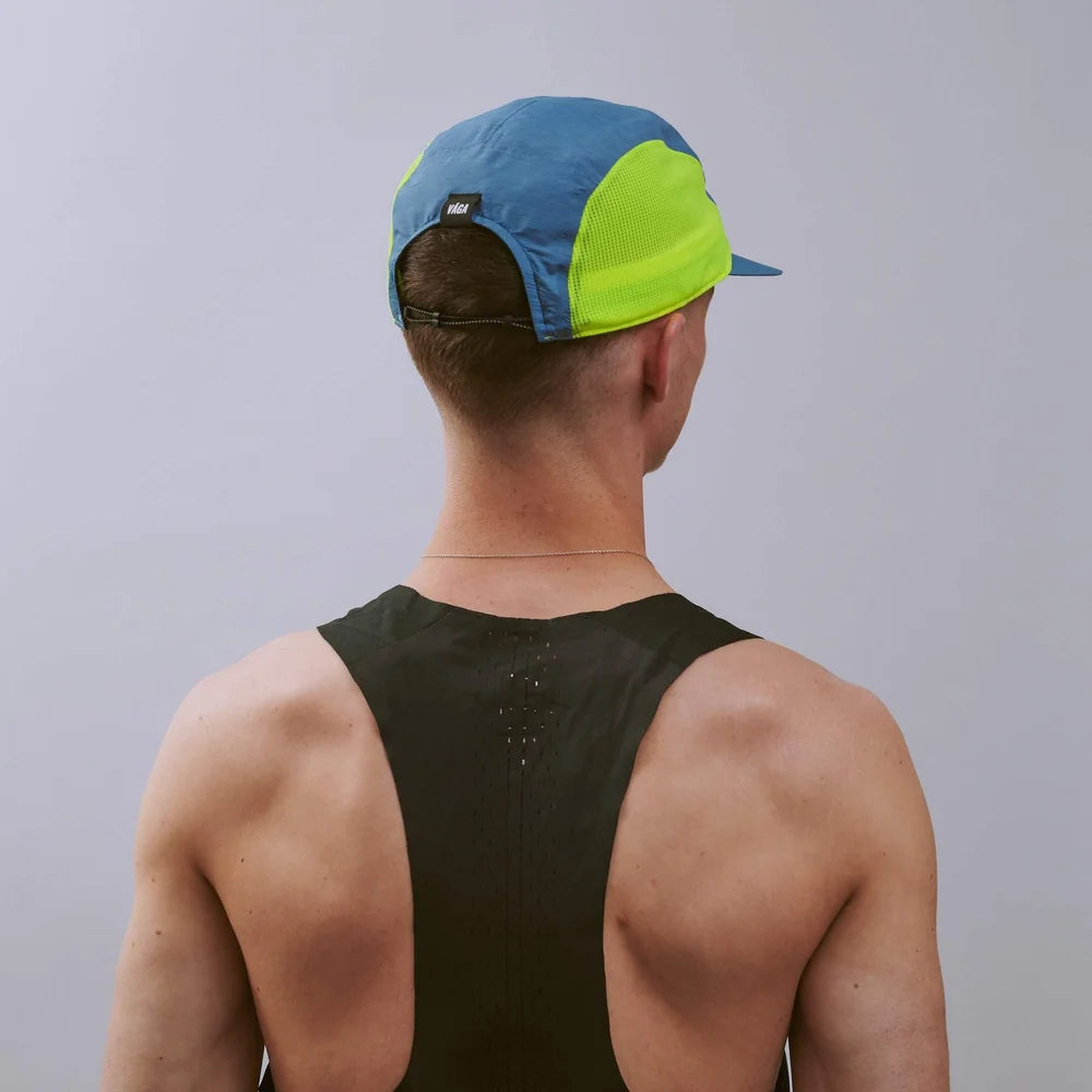 Person wearing a blue and green cap from behind on a plain background