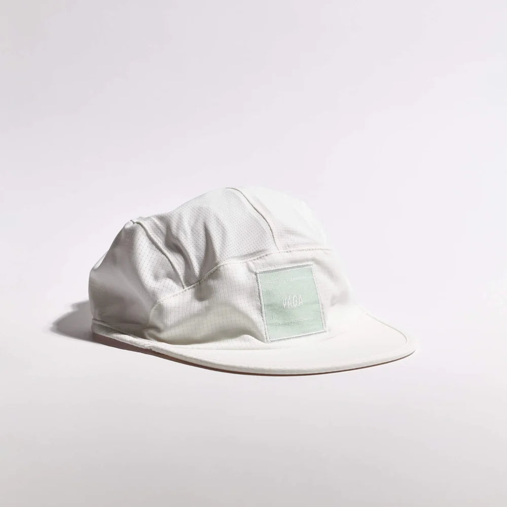 A light gray 5-panel camp cap with a small pale green rectangular patch on the front, photographed on a clean white studio background.