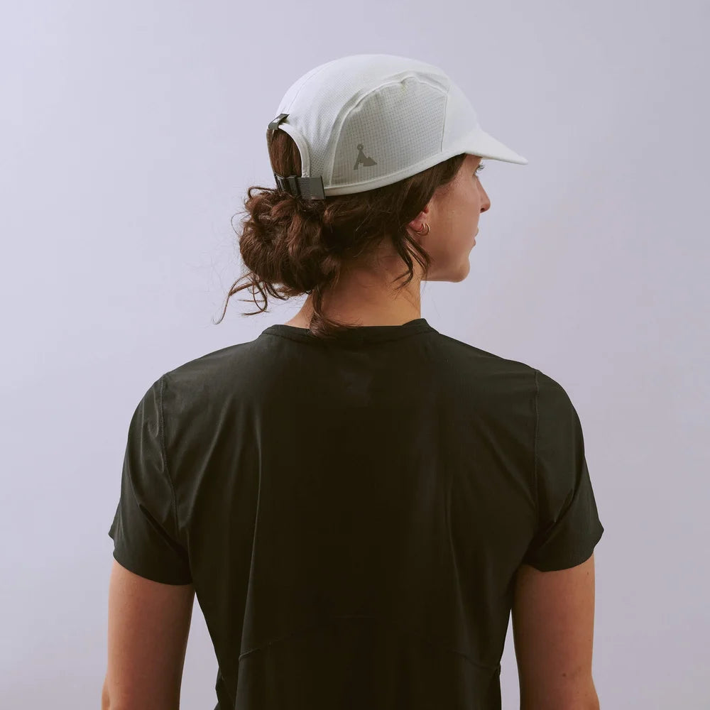Person wearing a white cap and black t-shirt against a light gray background