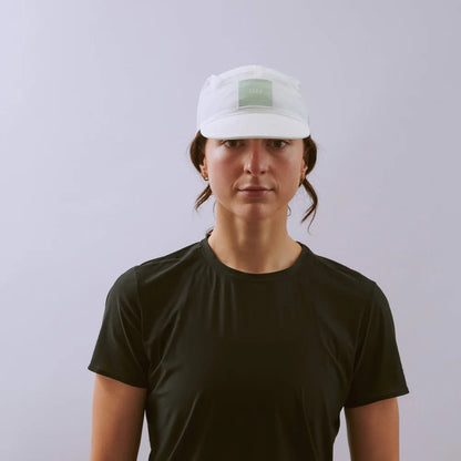 Person wearing a white cap and black t-shirt against a plain background